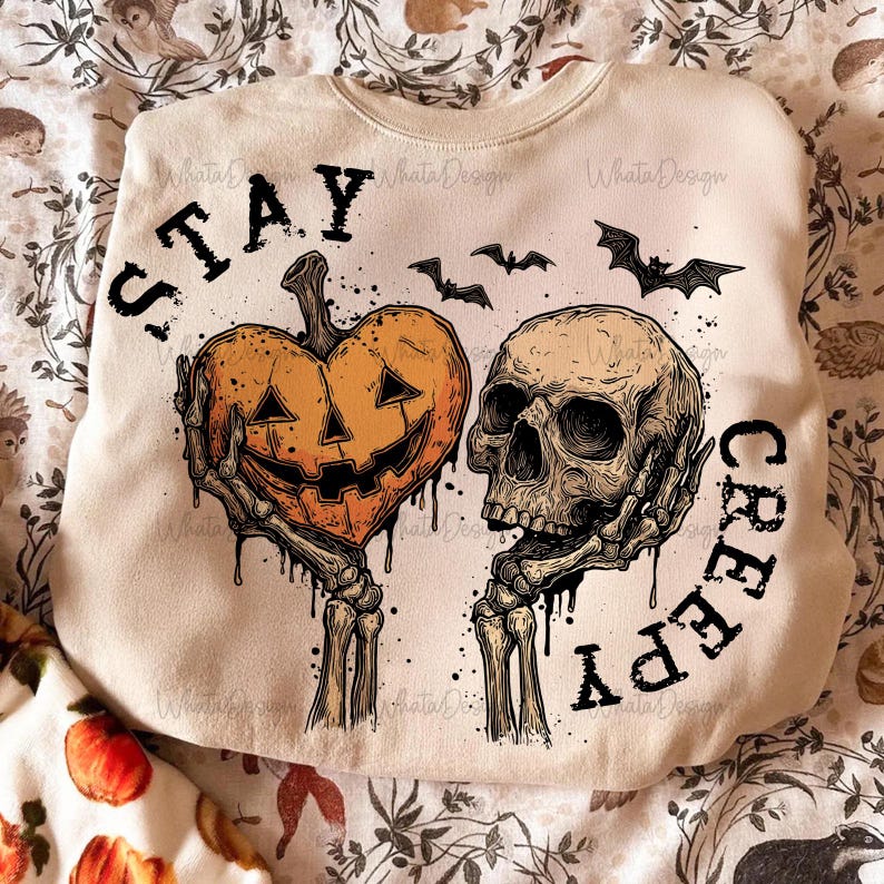 Puede incluir: Sudadera crema con dise&ntilde;o de Halloween. El gr&aacute;fico presenta una calabaza en forma de coraz&oacute;n y una calavera, sostenidas por manos esquel&eacute;ticas, con las palabras "STAY CREEPY" y murci&eacute;lagos. Un dise&ntilde;o espeluznante y festivo.