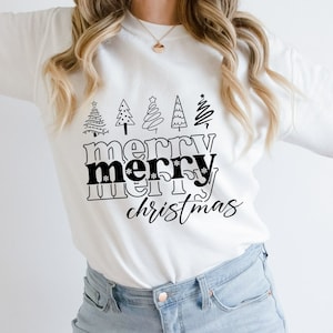 May include: White long-sleeve sweatshirt with a black graphic design. The design features five stylized Christmas trees above the words "merry merry christmas" in a bold, black font. The overall theme is festive and holiday-oriented.