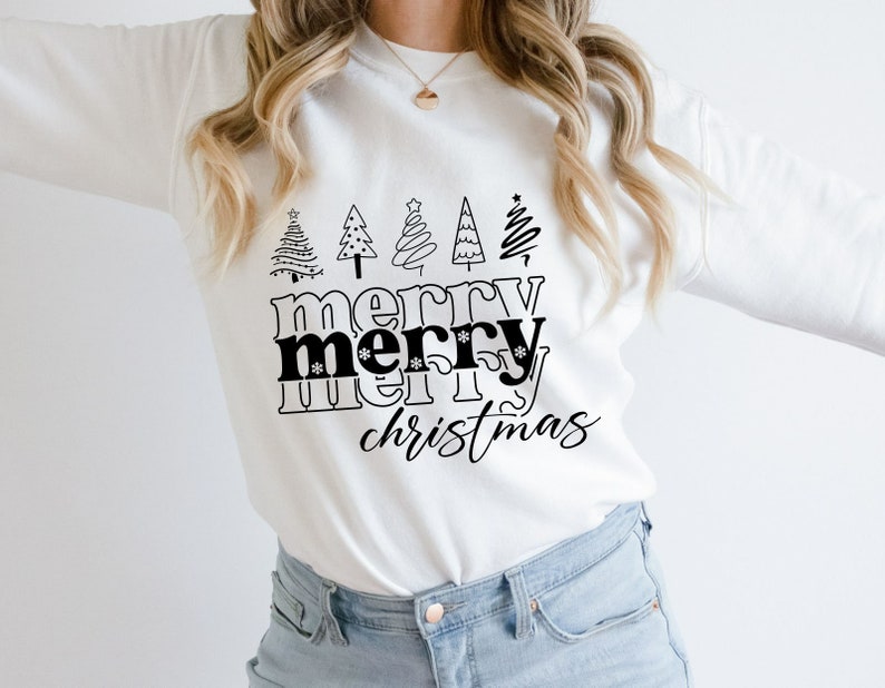 May include: White long-sleeve sweatshirt with a black graphic design. The design features five stylized Christmas trees above the words "merry merry christmas" in a bold, black font. The overall theme is festive and holiday-oriented.
