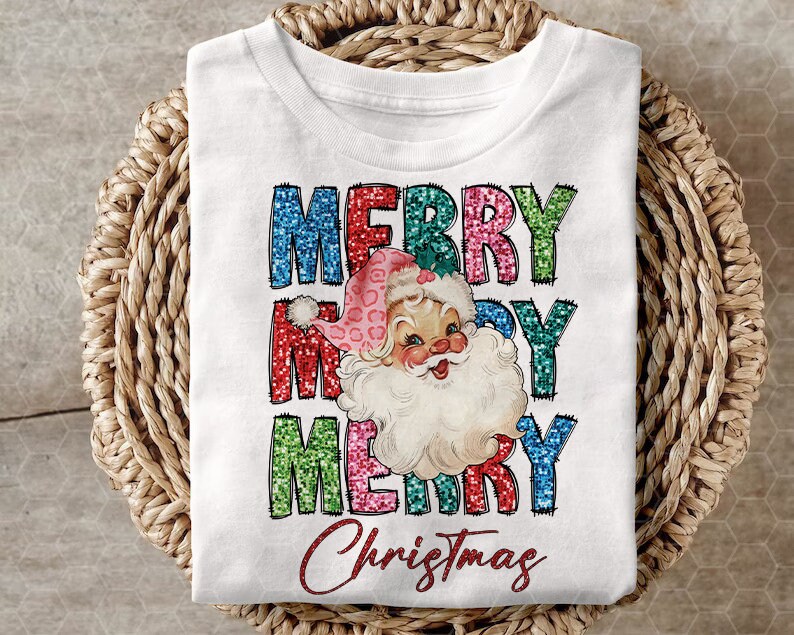 Op de afbeelding: Wit T-shirt met een kleurrijk glitterend "Merry Christmas" ontwerp met een vintage illustratie van de kerstman.