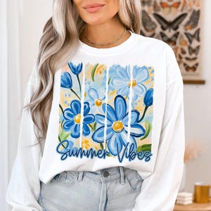 May include: White long-sleeve sweatshirt with a blue and yellow floral design and the text "Summer Vibes".