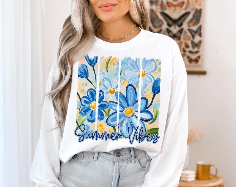 May include: White long-sleeve sweatshirt with a blue and yellow floral design and the text "Summer Vibes".