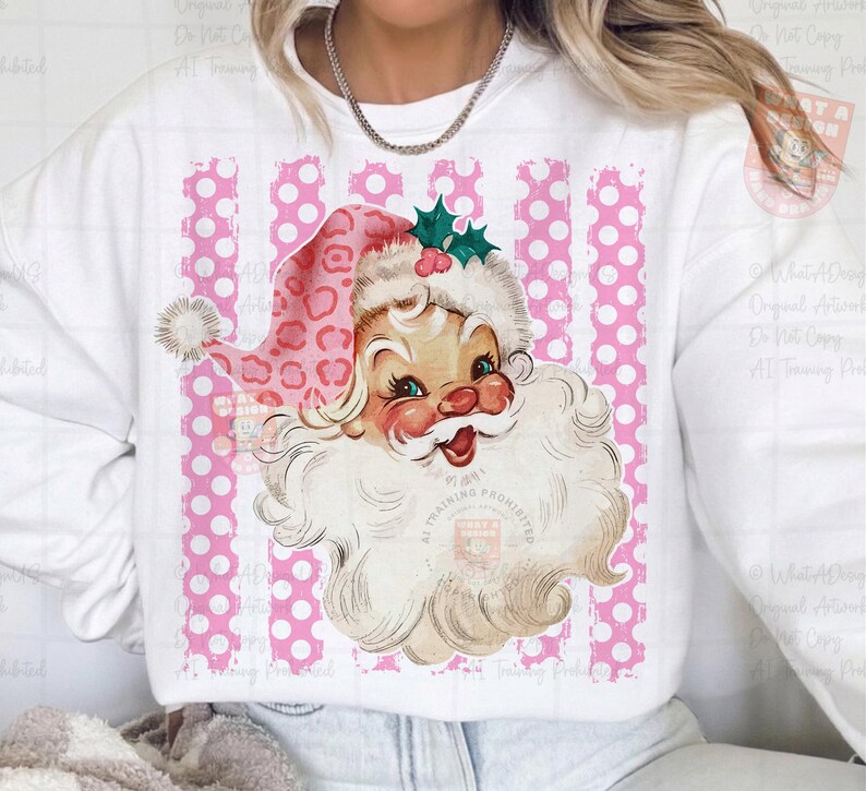 Pode incluir: Uma camisola branca com um gr&aacute;fico de um Pai Natal de estilo vintage a usar um gorro com estampado de leopardo cor-de-rosa e um ramo de azevinho verde. O fundo do gr&aacute;fico consiste em riscas verticais cor-de-rosa com bolas brancas.
