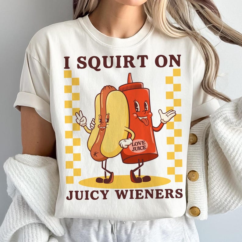 May include: White t-shirt with a graphic of a hot dog and ketchup bottle with the text "I squirt on juicy wieners".