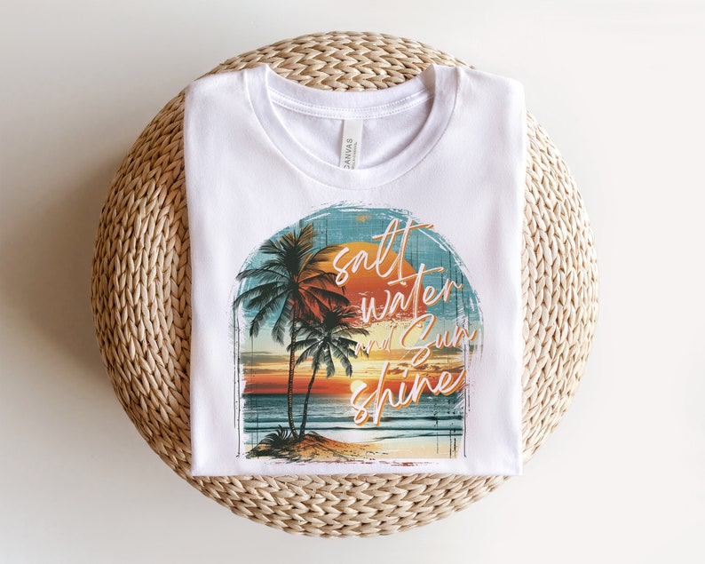 May include: White t-shirt with a graphic of palm trees, a sunset, and the text "salt water and sun shine".