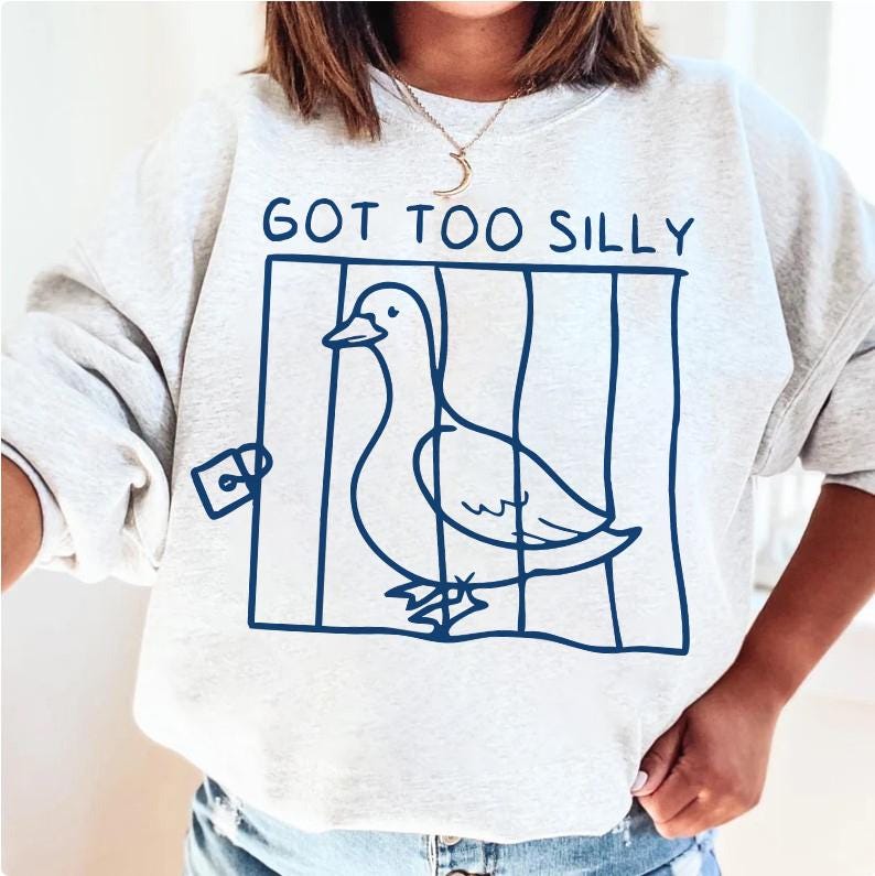 May include: A gray sweatshirt with a blue graphic of a duck in a cage. The text "GOT TOO SILLY" is above the graphic.