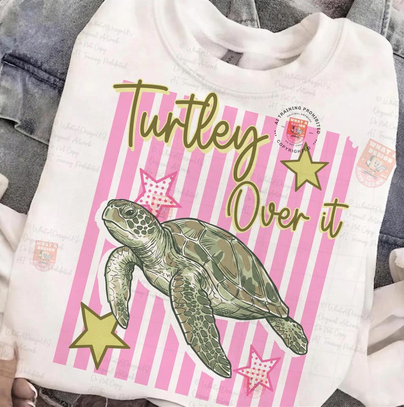May include: White sweatshirt with a graphic of a sea turtle, pink and white striped background, and the text "Turley Over it". The design includes yellow stars and pink stars.