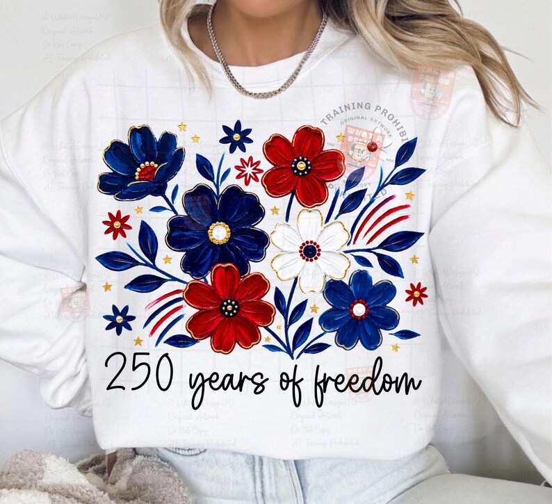 May include: White sweatshirt featuring a floral design in red, white, and blue. The design includes stylized flowers, leaves, and the text "250 years of freedom" in a script font. The sweatshirt has a crew neck.