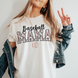 May include: White t-shirt with the text "Baseball Mama" in black lettering with a red baseball stitch design. A white baseball with red stitching is below the text.