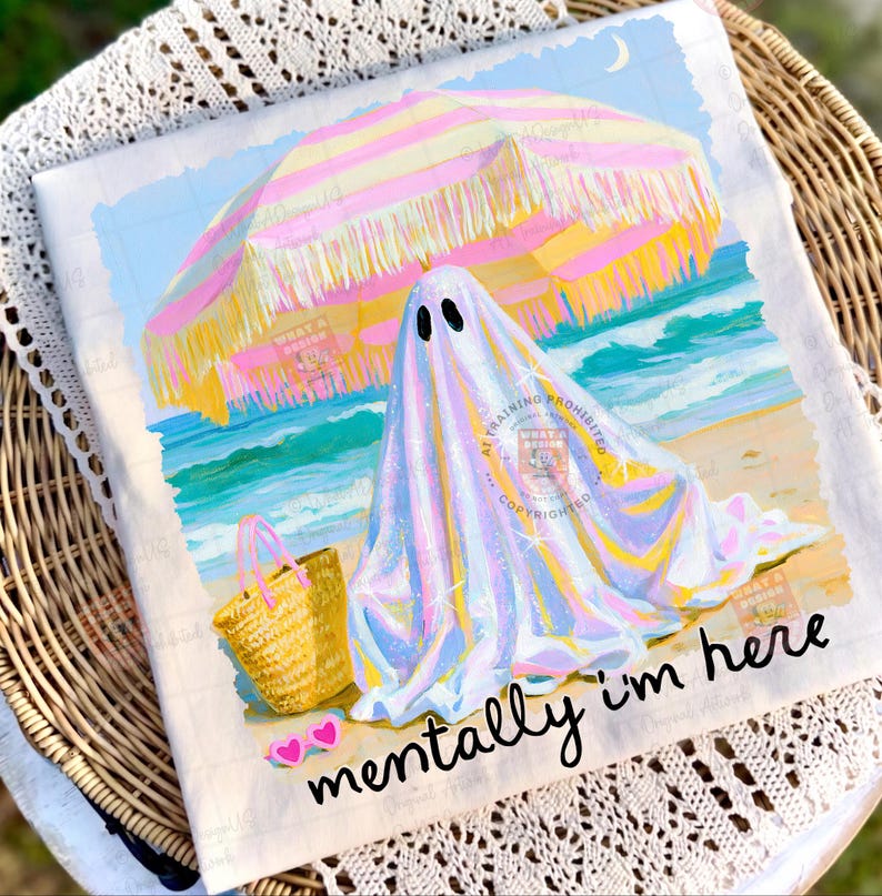 May include: A white t-shirt featuring a graphic of a ghost under a pink and yellow striped beach umbrella on a sandy shore with a straw tote bag and pink heart-shaped sunglasses. The text "mentally i'm here" is printed in black cursive script.