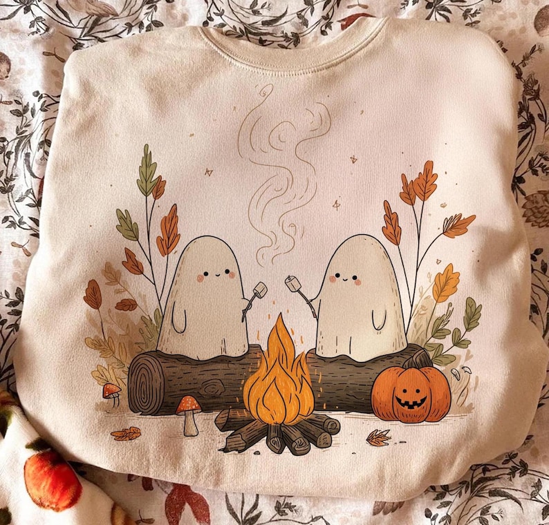 Digital Camping Ghosts Halloween PNG design featuring two ghosts around a campfire with a pumpkin and autumn leaves.