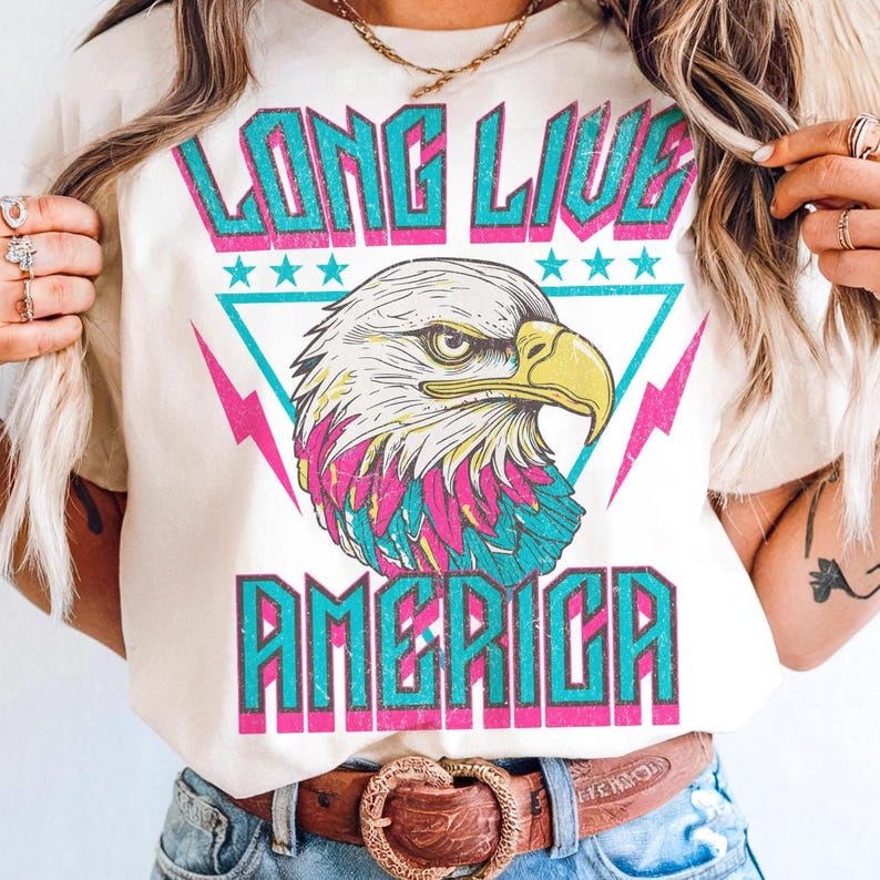 May include: A white t-shirt with a graphic print of an eagle with the text "Long Live America" in a retro style.