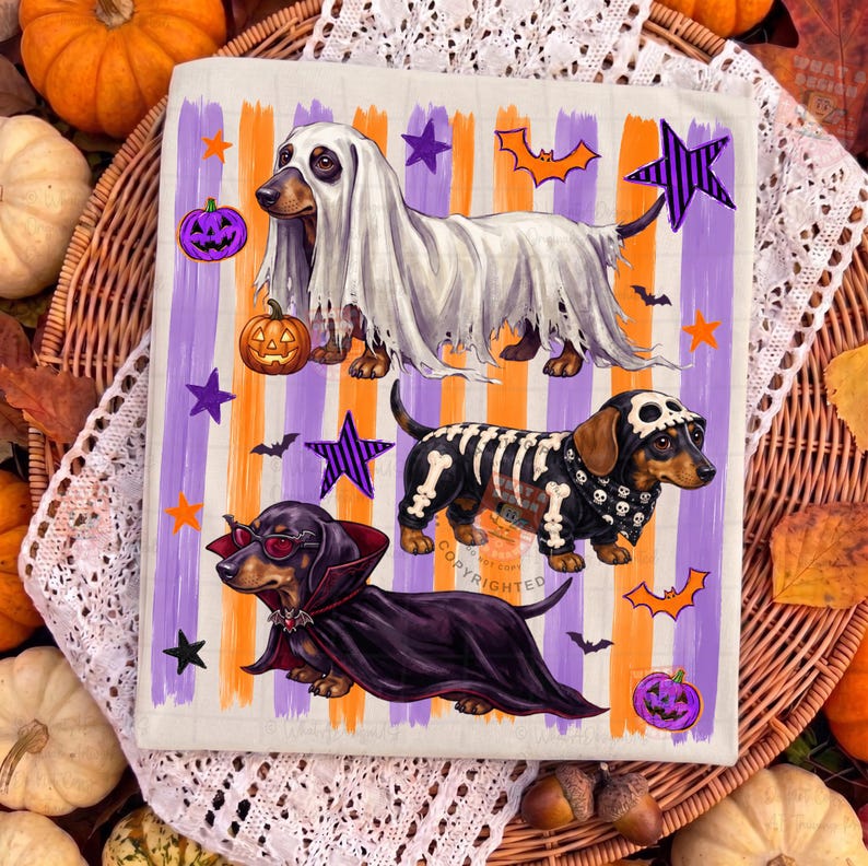 May include: A rectangular fabric print featuring three dachshunds in Halloween costumes against a background of vertical orange and purple stripes. One dog wears a ghost sheet, one a skeleton suit, and one a vampire cape with red glasses.