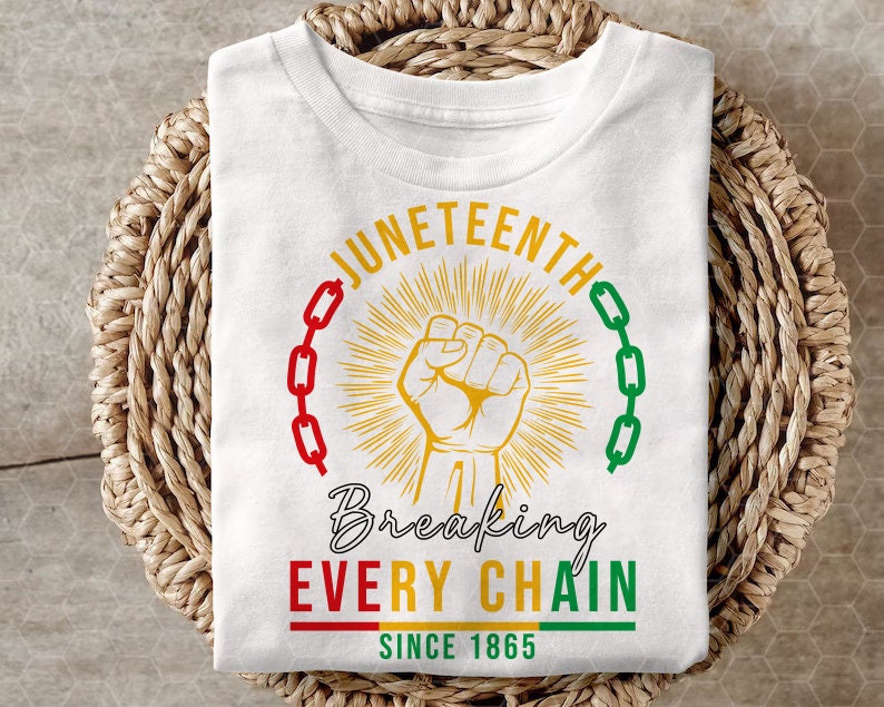 Peut inclure: T-shirt blanc avec un motif graphique repr&eacute;sentant un poing lev&eacute; brisant une cha&icirc;ne. Le texte "Juneteenth" est en cercle autour du poing, et le texte "Breaking Every Chain Since 1865" est sous le poing.