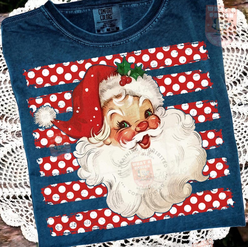 May include: A dark blue t-shirt with a vintage-style graphic of Santa Claus wearing a red hat with a white pom-pom and holly leaves. The background of the graphic features horizontal red stripes with white polka dots across the chest area.
