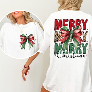 K&ouml;nnte beinhalten: Wei&szlig;es T-Shirt mit einer gr&uuml;n-roten Schleife und dem Text "Merry Merry Christmas" auf der R&uuml;ckseite.