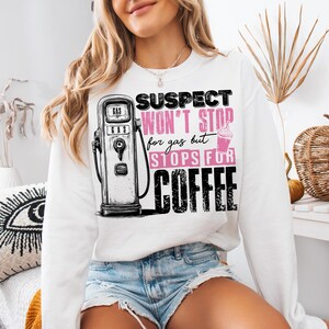 May include: White sweatshirt with a graphic of a gas pump and the text "Suspect won't stop for gas but stops for coffee".