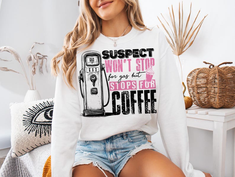 May include: White sweatshirt with a graphic of a gas pump and the text "Suspect won't stop for gas but stops for coffee".