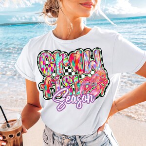 May include: White t-shirt with a colorful graphic that says "Crawfish Season" with a pink crawfish illustration.