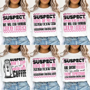 May include: Six white sweatshirts with pink and black text and graphics. The text on the sweatshirts reads "SUSPECT" and includes various humorous sayings.