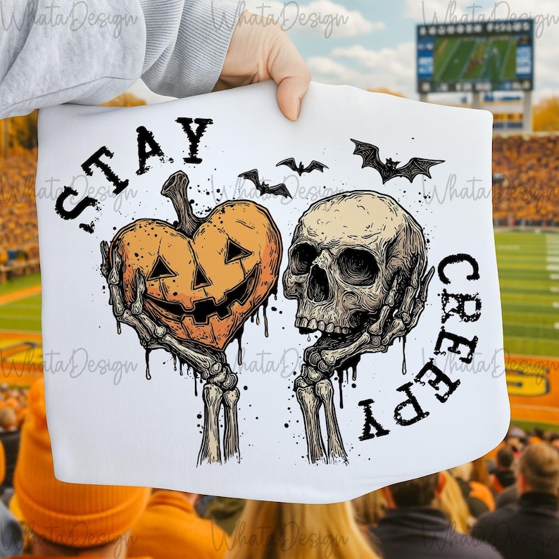 Puede incluir: Gr&aacute;fico blanco de Halloween con una calabaza en forma de coraz&oacute;n y una calavera, ambos sostenidos por manos esquel&eacute;ticas. Las palabras "STAY CREEPY" est&aacute;n impresas en negro. Tambi&eacute;n se incluyen murci&eacute;lagos.
