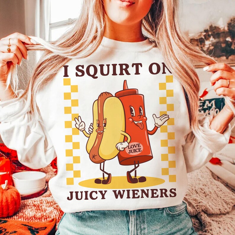 May include: White sweatshirt with a graphic of a hot dog and ketchup bottle with the text "I SQUIRT ON JUICY WIENERS" and the text "LOVE JUICE" on the ketchup bottle.