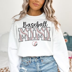 May include: White sweatshirt with the text "Baseball Mimi" in black lettering with a baseball graphic. The text is surrounded by a red and white baseball stitch design.