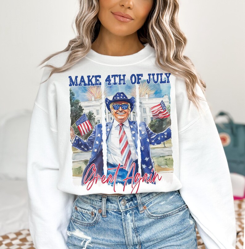 May include: White crewneck sweatshirt with a graphic featuring a man in a cowboy hat and a suit with American flag details. The text "MAKE 4TH OF JULY" and "Great Again" are displayed above and below the image.