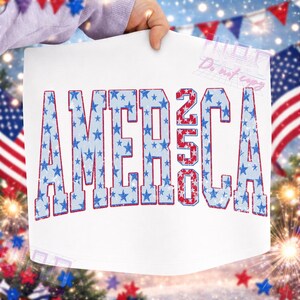 May include: White rectangular print with the word "AMERICA" in large, distressed, blue letters filled with blue stars. The number "250" is in red. The print is held up by a person.