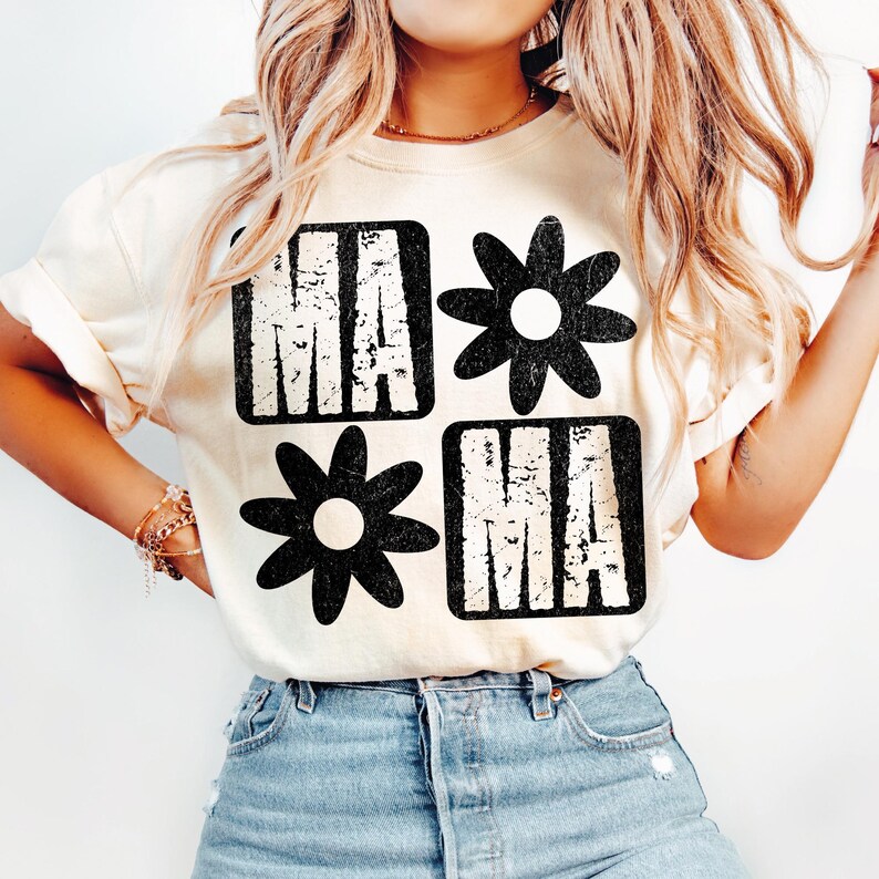 Peut inclure: Un t-shirt blanc avec un motif graphique noir qui dit "MAMA" avec un motif de fleur de chaque c&ocirc;t&eacute;.