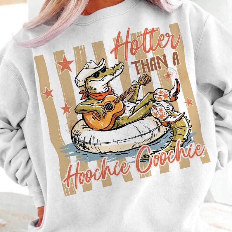 May include: White sweatshirt with a graphic of an alligator wearing a cowboy hat, sunglasses, and boots, playing a guitar while floating on an inner tube. Text reads "Hotter Than A Hoochie Coochie."