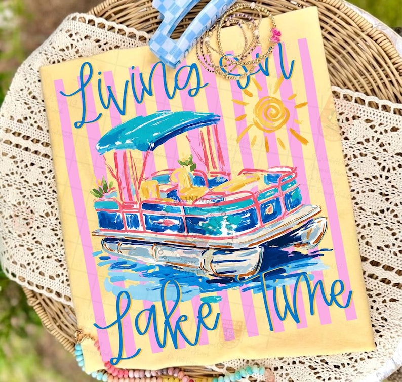 May include: A yellow tote bag with pink stripes and a painted pontoon boat design. The words "Living on Lake Time" are written in blue script. The boat is blue, pink, and white with a turquoise canopy and a yellow sun.