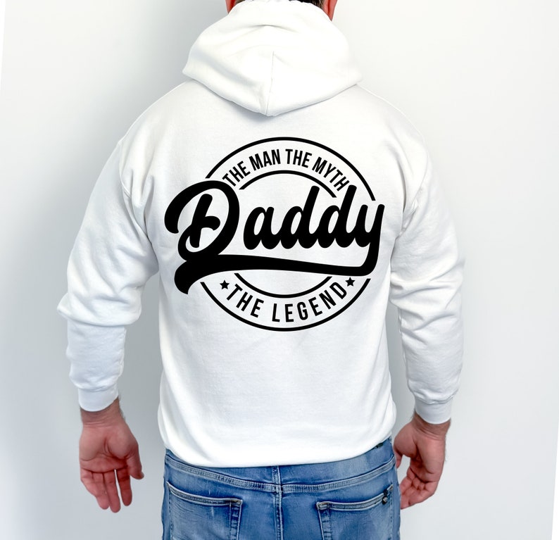 May include: White hooded sweatshirt with a black circular design on the back that says "The Man The Myth Daddy The Legend".