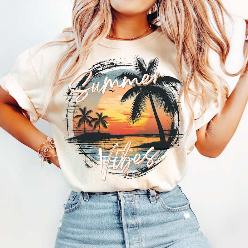 May include: A white t-shirt with a graphic print of a sunset over the ocean with palm trees and the text "Summer Vibes".