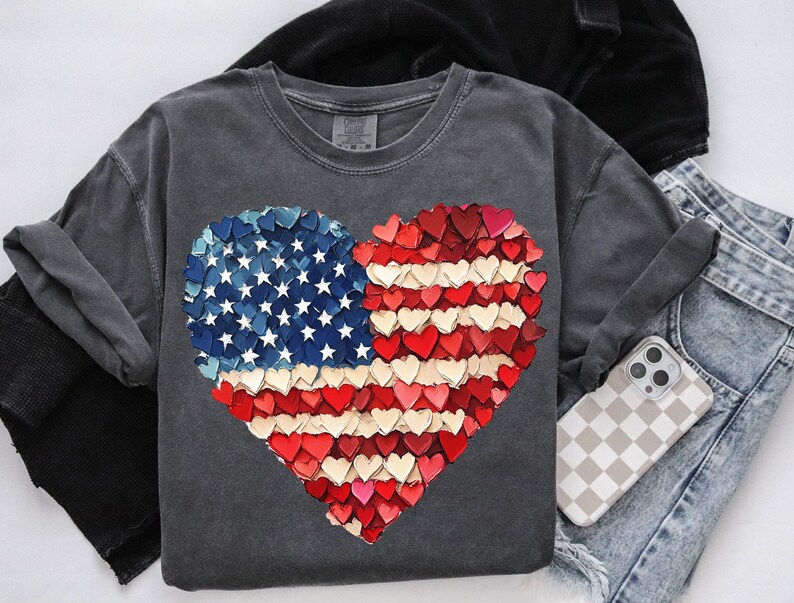 May include: A charcoal gray t-shirt with a heart-shaped design made of red, white, and blue hearts. The design resembles the American flag.