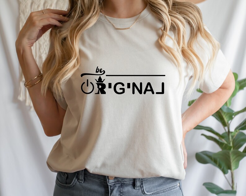 May include: A white t-shirt with black text that reads "be original" with a crown and an on/off switch graphic.