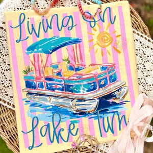 May include: A canvas art piece with a yellow background and pink vertical stripes. The artwork features a blue and white pontoon boat with the words "Living on Lake Fun" in blue script. A yellow sun is in the upper right corner.