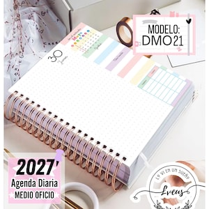 Puede incluir: Una agenda diaria 2027 con encuadernación en espiral color cobre. La página abierta presenta un diseño de cuadrícula de puntos, un calendario pequeño de mayo y secciones en tonos pastel para notas y gastos. El texto incluye 30 Jueves, 2027 Agenda Diaria MEDIO OFICIO y MODELO: DMO21.