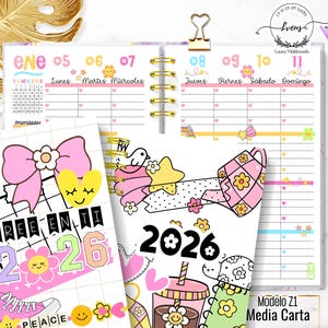 May include: A decorative spiral-bound planner with a 2026 cover. The planner has weekly and monthly layouts with illustrations of flowers, stars, and hearts. The text "CREE EN TI" is visible. A pink pen is also visible. The planner is in a half-letter size.