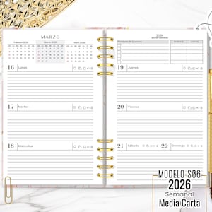 Peut inclure: Agenda ouverte avec reliure spirale dorée, présentant une mise en page hebdomadaire pour mars 2026. Les pages sont lignées avec un motif marbré. Un stylo doré repose sur le côté droit. Le texte comprend "MODELO S06 2026 Semanal Media Carta".