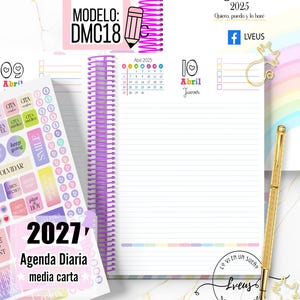 May include: A 2027 daily planner with a purple spiral binding, featuring a sticker sheet with colorful labels, a gold pen, and a cat-shaped paperclip. The planner pages display the date April 10, 2025, with a calendar, lined writing space, and text.