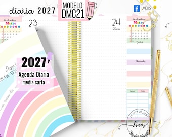May include: A 2027 daily planner with a rainbow-patterned cover and a gold spiral binding. The interior pages feature a dotted grid layout, a March calendar, and sections for gratitude and expenses. A gold pen is positioned next to the open planner.