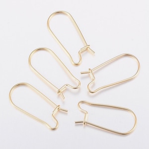 Puede incluir: Cuatro ganchos para pendientes de color dorado, cada uno con un diseño simple de forma ovalada.