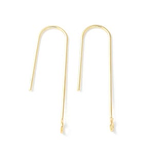 Peut inclure: Une paire de boucles d'oreilles minimalistes de couleur or. Chaque boucle d'oreille présente une longue tige droite qui se courbe en un sommet arrondi, créant une forme de U. Le bas de chaque boucle d'oreille a une petite boucle. Les boucles d'oreilles sont sur fond blanc.