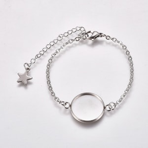 Peut inclure: Un bracelet en chaîne argentée avec un charme rond en verre transparent et un charme en forme d'étoile suspendu à la chaîne.
