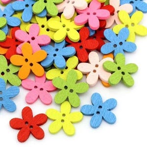 Puede incluir: Surtido de botones de madera de colores en forma de flor. Los botones tienen cinco pétalos y dos agujeros. Los colores incluyen rojo, naranja, amarillo, verde, azul y rosa.