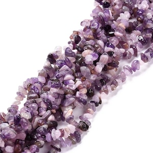 May include: A strand of purple amethyst chip beads. The beads are irregular in shape and have a natural, tumbled finish.