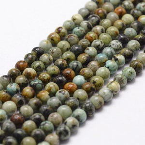 Può includere: Una collana di perline rotonde in turchese verde, marrone e nero. Le perline hanno un diametro di circa 6 mm.