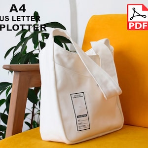 May include: White canvas tote bag with a pocket and a label that says "Quality First Leading the Fashion" and "Collection". The bag is sitting on a yellow chair.