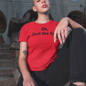 May include: A red t-shirt with the text "Ok, just the tip" printed in black.